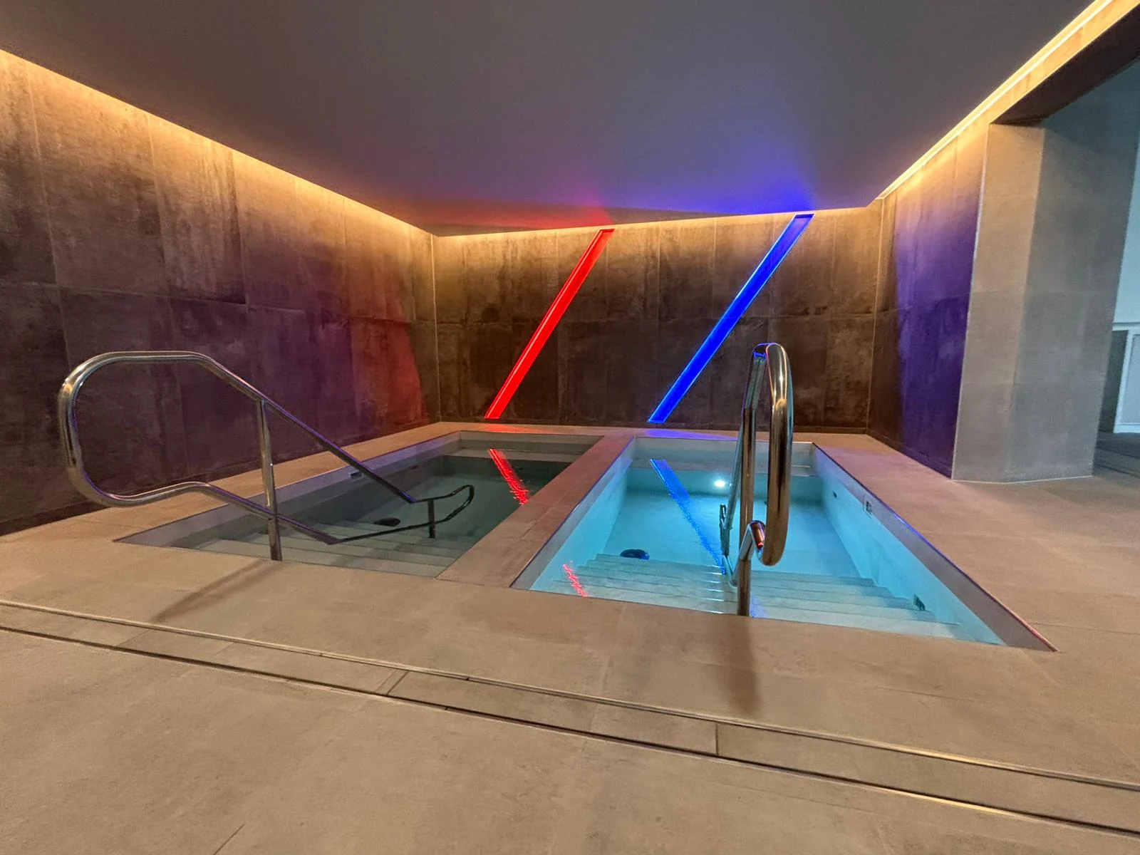 Rehabilitation pool area with access handrails and red and blue feature lighting