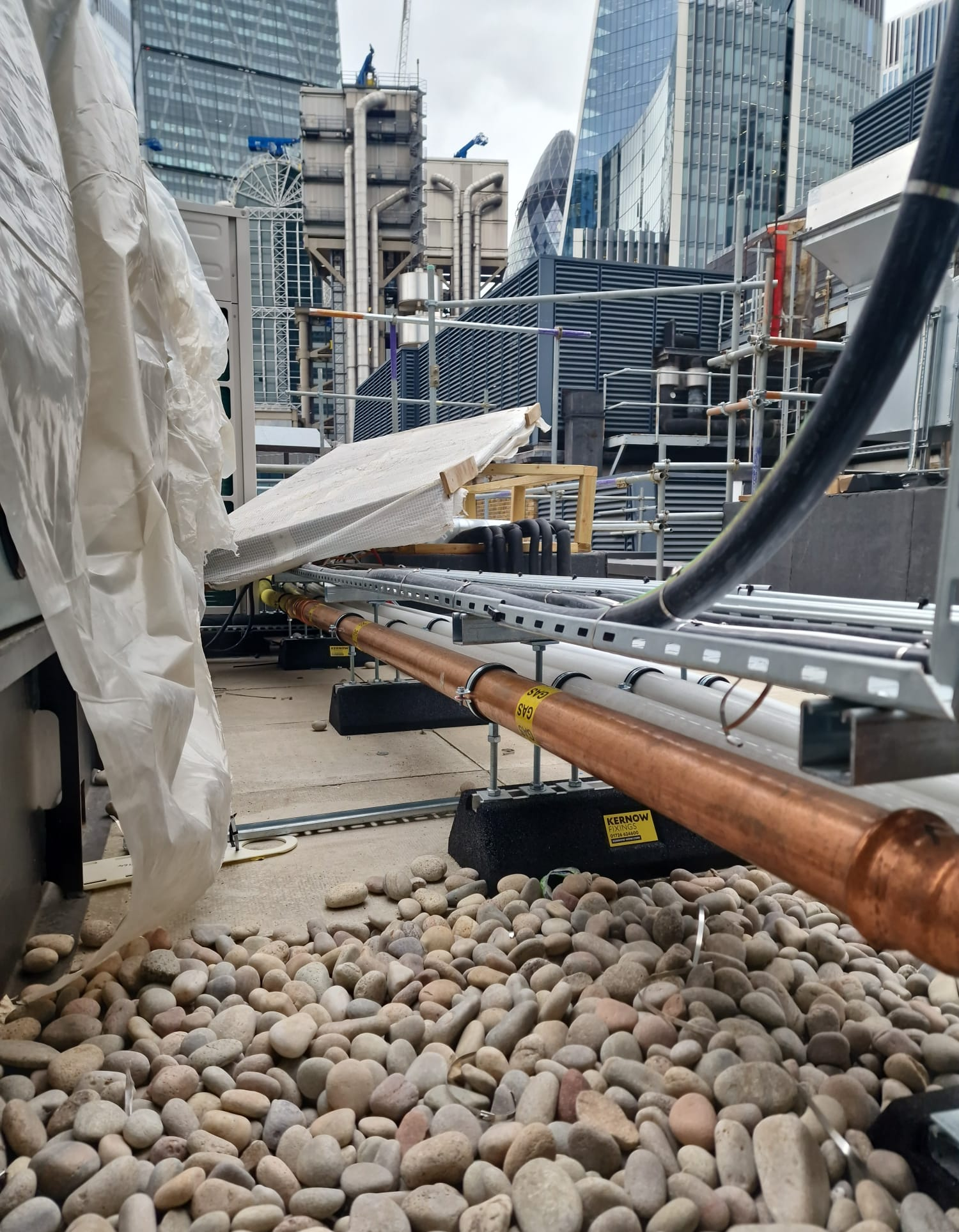 Copper gas pipework supported along the roof with the City skyline beyond
