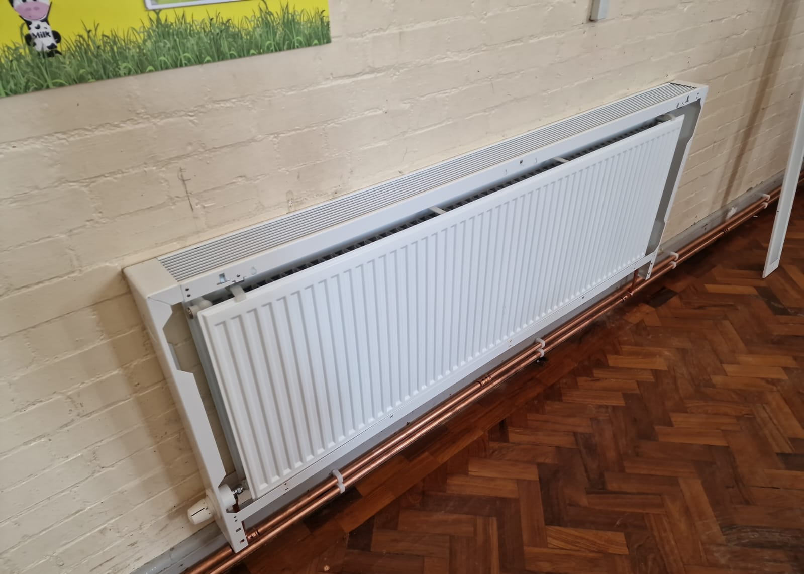 Radiator within an LST casing frame, with the front cover removed and copper connections visible