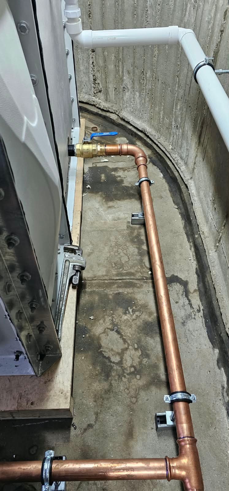 Copper pipework, isolation valve and supported connections beside the sectional tank