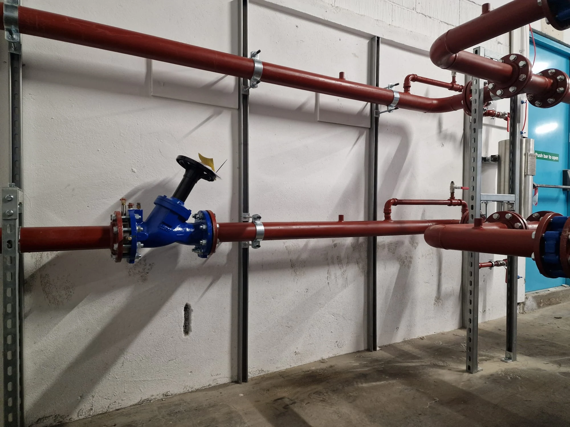 LTHW primary pipework runs with flanged connections and support brackets